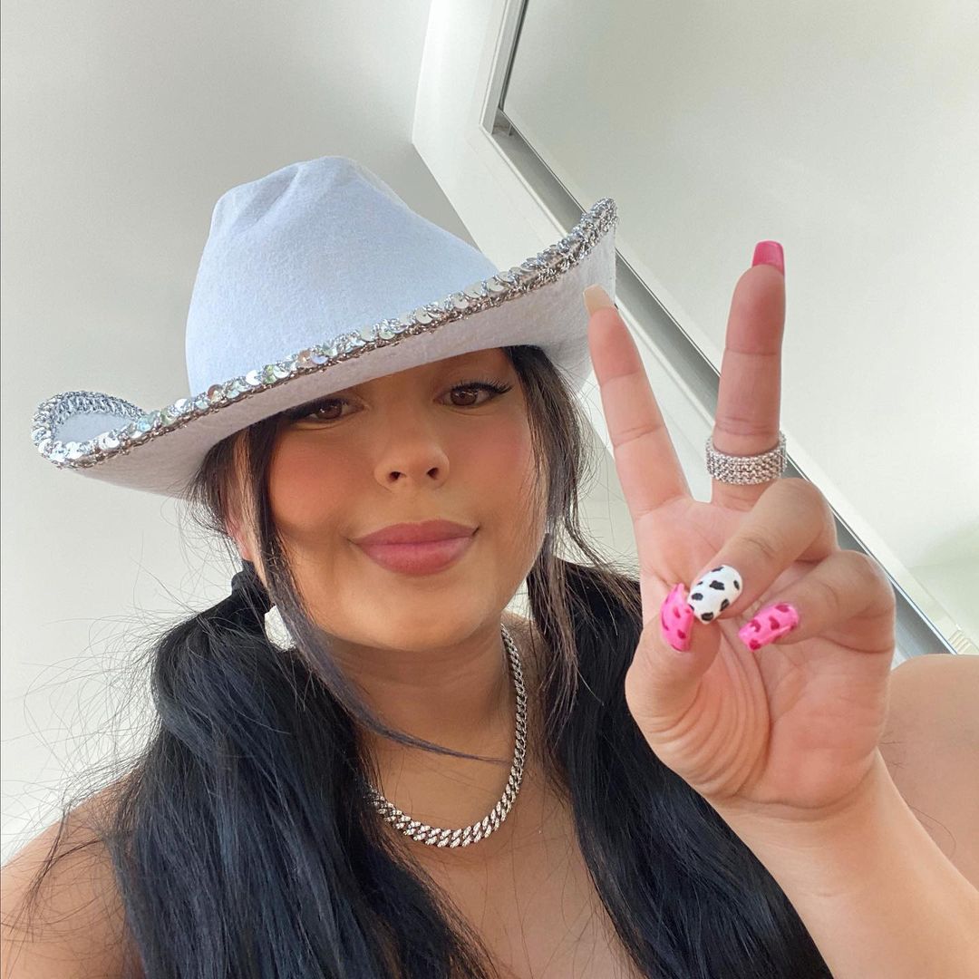 Lauren Jasmine with a white hat displaying victory sign