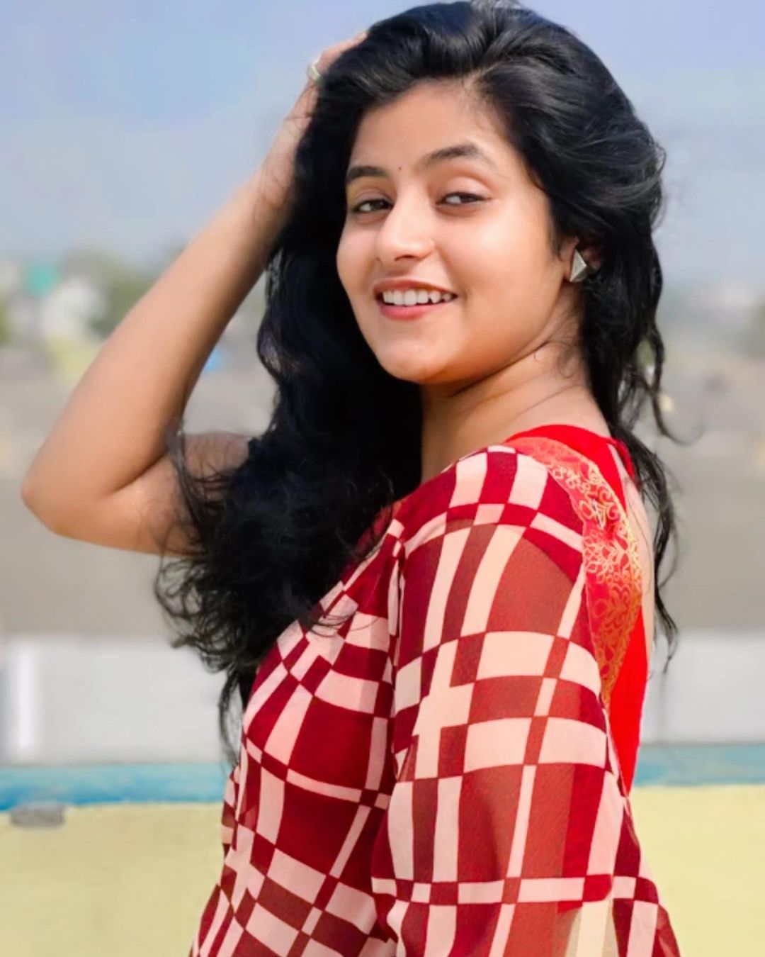 Sanchita Basu with open hair in red checked saree